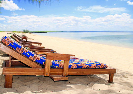 Ligbedden aan het strand tijdens vakantie in Mozambique